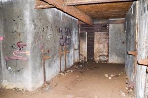 Ligne Maginot - 113 - OLTINGUE - (Casemate d'artillerie) - Chambre de tir de droite. Vue coté entrée des munitions qui donnait directement dans la pièce servant également de chambre de repos avec 8 lits, les supports sont encore en place. 
Au plafond, se trouve le monorail Tourtelier utilisé pour la mise en place de la pièce sur son support