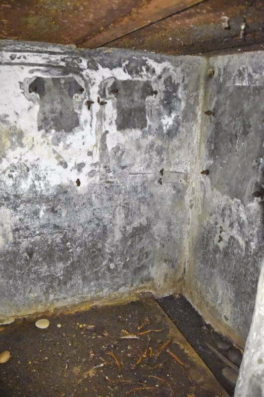 Ligne Maginot - 6M - (Chambre de coupure) - Mur du fond de la chambre. A droite les traces du boitier répartiteur, à gauche les 2 boîtiers de protection pour les lignes de campagne pouvant se raccorder sur la chambre de coupure (2x6 lignes). Au sol un caniveau.