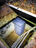 Ligne Maginot - U1 - (Chambre de coupure) - Vue complète sur le petit 'puits de coupure' U1 : la chambre semble utilisée pour un but indéterminée. Des panneaux en métal remplacent l'ancienne trappe, et une poubelle vide est présente dans le local.