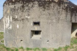 Ligne Maginot - MB121 - (Blockhaus pour canon) - Blockhaus en plein champ, forêt à proximité. La façade et les crenaux de tir