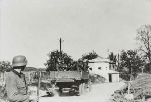 Ligne Maginot - SPICHEREN (MF DE) - (Poste GRM - Maison Forte) - Vue du coté route, les allemands passent devant l'avant poste dont la barrière a été réouverte.
Noter que l'avant poste ne comporte aucune trace de combat et que la partie casernement à l'arrière  est intacte