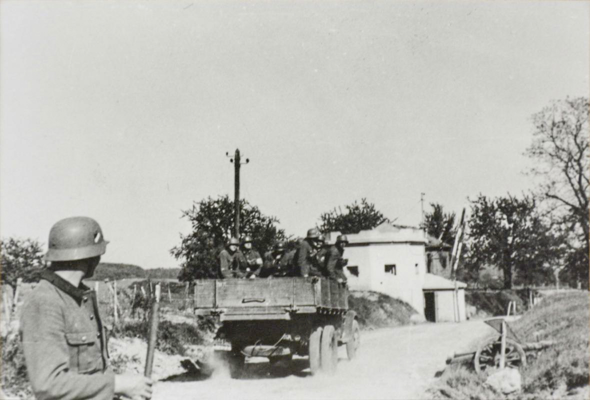 Ligne Maginot - SPICHEREN (MF DE) - (Poste GRM - Maison Forte) - Vue du coté route, les allemands passent devant l'avant poste dont la barrière a été réouverte.
Noter que l'avant poste ne comporte aucune trace de combat et que la partie casernement à l'arrière  est intacte