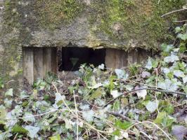 Ligne Maginot - E - CÔTE DU RÛ SUD - (Blockhaus pour arme infanterie) - Face gauche, créneau Hotchkiss.  On aperçoit à gauche du cliché le mur pare-éclats de l'entrée droite.