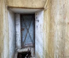 Ligne Maginot - 21M - (Chambre de coupure) - Couloir intérieur : la porte du local téléphonique, l'évacuation des eaux, et l'emplacement du boîtier de connexion sur le mur de droite.