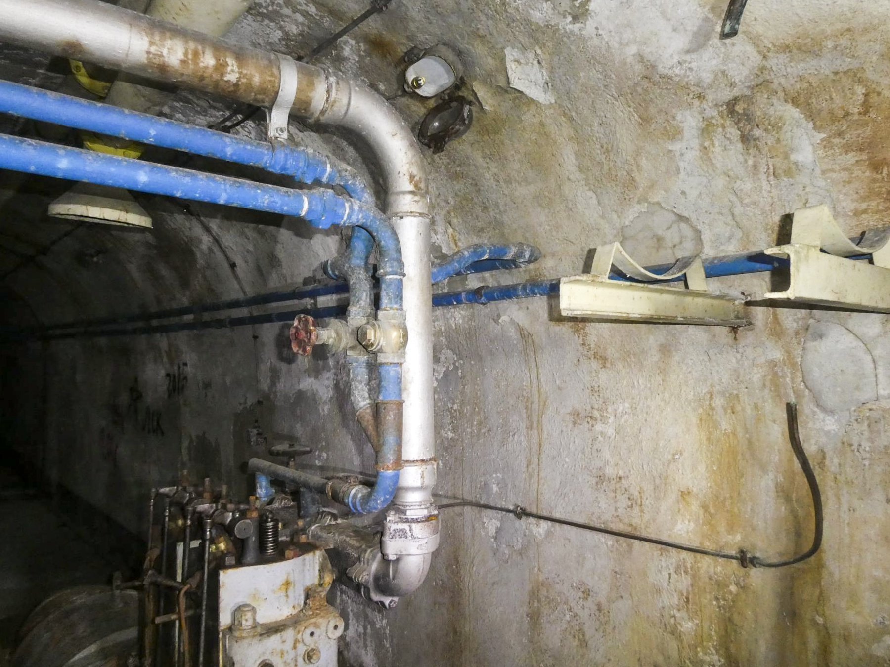 Ligne Maginot - COL DE GARDE (G) - EO10 - (Abri actif) - L'usine électrique
En gris le tuyau d'évacuation des gaz moteur. A droite le support du réservoir de 55 litres de fuel et au même niveau l'arrivée d'eau des réservoir principaux du bloc 2 pour alimenter la cuve de refroidissement. - ELLENA Daniel - CUNY Philippe