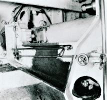 Ligne Maginot - Lunette de visée APX L673 (L673) - Ouvrage de Fermont bloc 4
Le cache latéral étant démonté et la lunette retirée, la tringlerie de commande du prisme mobile situé en tête de la lunette est visible sur cette photo ainsi que le renvoi la commandant depuis la tringle de commande de hausse de la pièce (à droite de la photo)
Le petit volant sert au réglage de base de la lunette