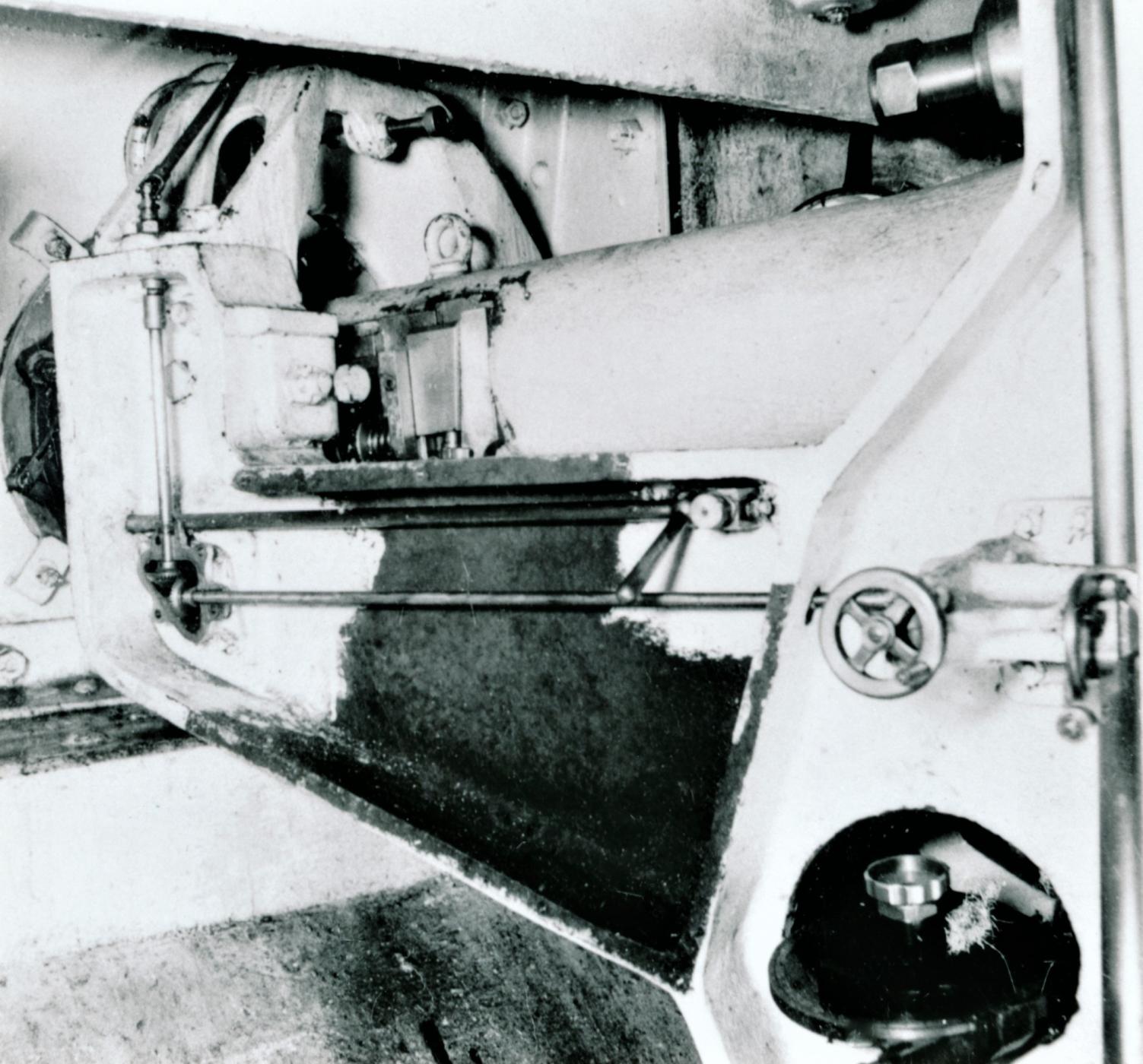 Ligne Maginot - Lunette de visée APX L673 (L673) - Ouvrage de Fermont bloc 4
Le cache latéral étant démonté et la lunette retirée, la tringlerie de commande du prisme mobile situé en tête de la lunette est visible sur cette photo ainsi que le renvoi la commandant depuis la tringle de commande de hausse de la pièce (à droite de la photo)
Le petit volant sert au réglage de base de la lunette