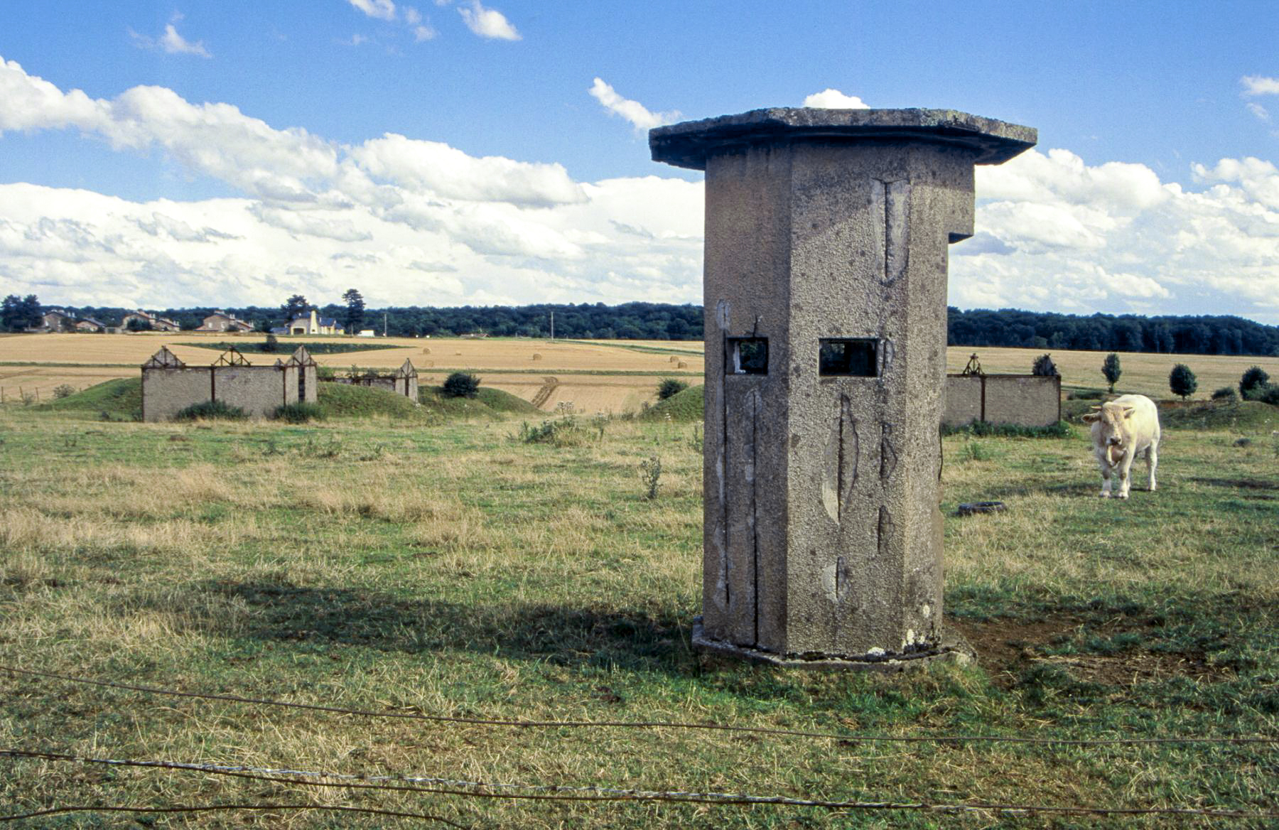 Ligne Maginot - MORFONTAINE - (Dépôt de Munitions) - Entrée du dépôt en 1999. On aperçoit au second plan les bâtiments du dépôt, entre leurs alvéoles. 
La cité des cadres du camp de Morfontaine est visible à l'horizon.